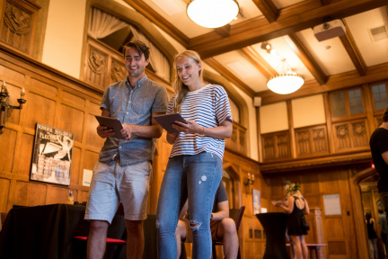 young-adults-walking-with-ipads-inside-bakken-museum-at-an-event