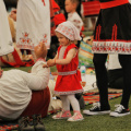 free-photo-of-a-little-girl-in-a-traditional-outfit-among-adults-at-a-festival