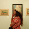 free-photo-of-woman-in-hat-and-dress-standing-in-art-gallery